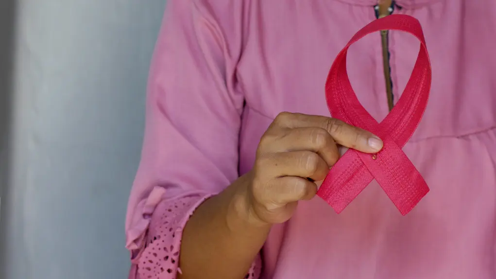 A woman holding breast cancer ribbon